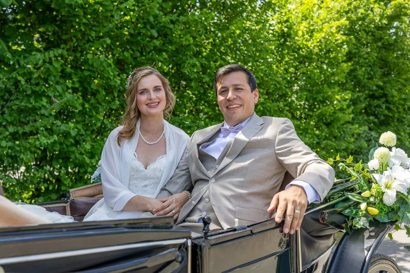 Brautpaar bei einer romantischen Hochzeitskutsche
